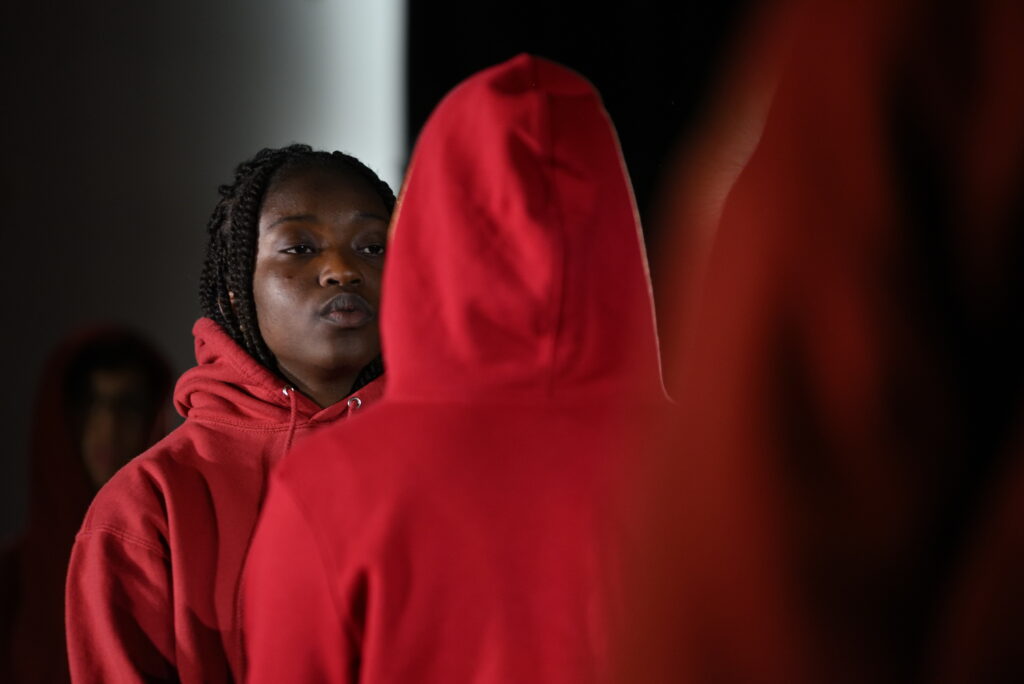 Une personne en pull rouge de dos, une autre de face